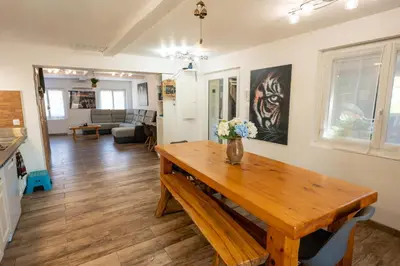 a kitchen and living room with a wooden table at Chez Simon, au fil de l'eau in Revel