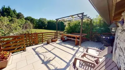 a patio with a bench and a wooden fence at Beau Gîte de Campagne 3 épis in Les Martys