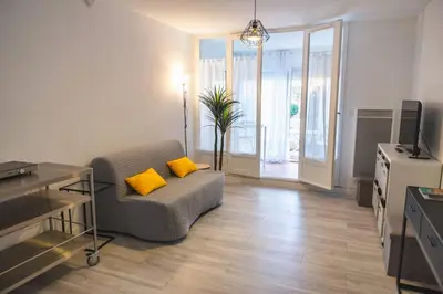 a living room with a couch with two yellow pillows at Le Petit Brigantin in Gruissan
