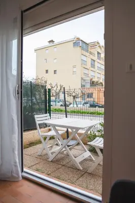 a white picnic table outside a sliding glass door at Le Petit Brigantin in Gruissan