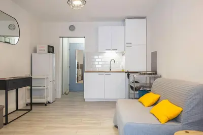 a living room with a couch and a kitchen at Le Petit Brigantin in Gruissan