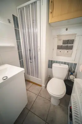 a bathroom with a white toilet and a sink at Le Petit Brigantin in Gruissan