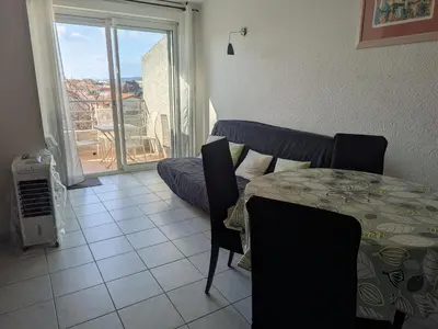 a dining room with a table and a balcony at Charmant T2 pour 4 pers à 100m de la plage avec balcon - FR-1-797-61 in Port-la-Nouvelle