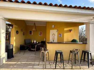 a patio with stools and a bar in a house at Villa T6 d'exception entre Toulouse et Carcassonne , Vue sur les Pyrénées in Trébons-sur-la-Grasse