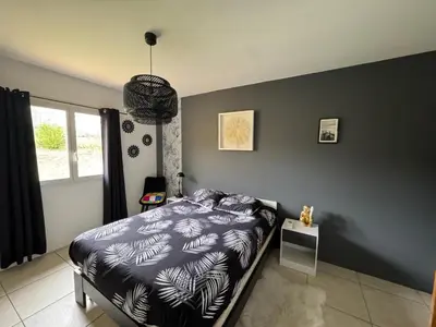 a bedroom with a bed and a black wall at Villa T6 d'exception entre Toulouse et Carcassonne , Vue sur les Pyrénées in Trébons-sur-la-Grasse