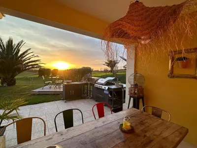 a patio with a table and a grill with the sunset at Villa T6 d'exception entre Toulouse et Carcassonne , Vue sur les Pyrénées in Trébons-sur-la-Grasse