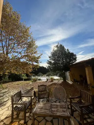 a group of chairs and a wooden table and bench at Maison viticole dans le Sud de la France avec grand piscine in Moussan