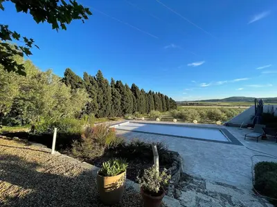 a swimming pool in a yard with trees in the background at Maison viticole dans le Sud de la France avec grand piscine in Moussan