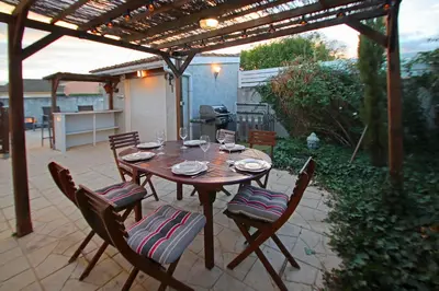 a wooden table and chairs on a patio at Magnifique villa avec piscine in Carcassonne