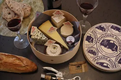 a box of cheese and bread and two glasses of wine at Magnifique villa avec piscine in Carcassonne