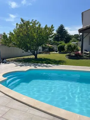 a large blue swimming pool in a yard at Villa Serenita in Villemoustaussou