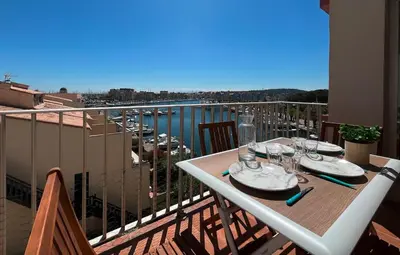 a table on a balcony with a view of a harbor at Appartement rénové avec vue marina Gruissan GN140-1033 in Gruissan