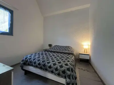 a small bedroom with a bed and a lamp at Appartement rénové avec vue marina Gruissan GN140-1033 in Gruissan