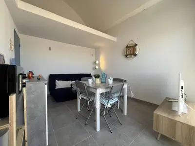 a living room with a table and a couch at Appartement rénové avec vue marina Gruissan GN140-1033 in Gruissan
