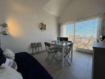 a bedroom with a table and a bed and a window at Appartement rénové avec vue marina Gruissan GN140-1033 in Gruissan
