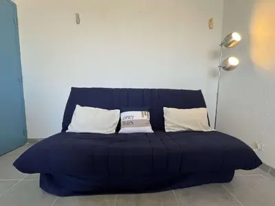 a blue couch with two white pillows on it at Appartement rénové avec vue marina Gruissan GN140-1033 in Gruissan
