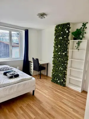 a bedroom with a bed and a green wall at Maison au coeur du Sidobre in Saint-Salvy-de-la-Balme