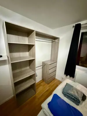 a bedroom with a bed and open shelves at Maison au coeur du Sidobre in Saint-Salvy-de-la-Balme