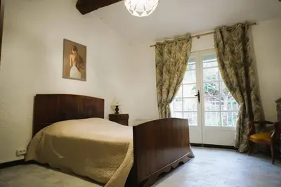 a room with a table with wine glasses and a clock at Lou Vidal - 6 Pers 5 minutes plage in Fitou