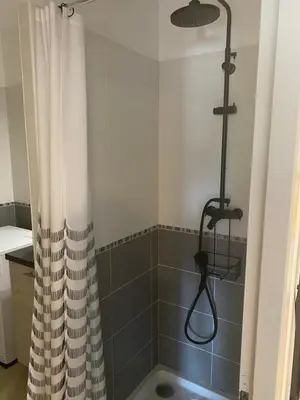 a shower with a shower curtain in a bathroom at Appartement tout confort climatisé in Gruissan