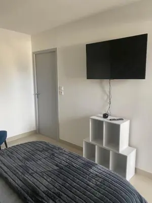 a bedroom with a bed and a flat screen tv at Appartement tout confort climatisé in Gruissan
