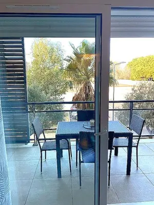a blue table and chairs on a balcony at Appartement tout confort climatisé in Gruissan