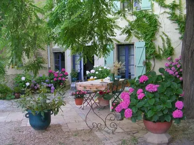 a bench in front of a house with flowers at Maison de Maitre Comfortable holiday residence in Ferrals-lès-Corbières