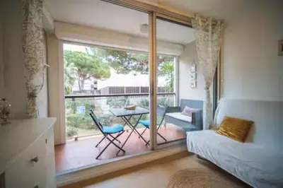 a bedroom with a large window and a table and chairs at L'Escale Marine in Gruissan