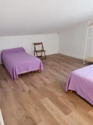 a room with two beds and a wooden floor at Charmant gîte au coeur des Corbières in Tuchan