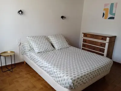 a bedroom with a bed and a wooden dresser at Charmant gîte au coeur des Corbières in Tuchan