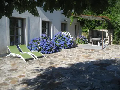 two green chairs sitting on a patio with flowers at Stylish villa with large pool and stunning views in Olargues