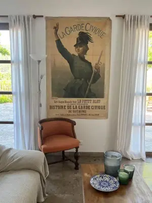 a living room with a poster of a woman holding a rifle at Stylish villa with large pool and stunning views in Olargues