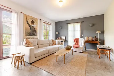 a living room with a white couch and a table at Stylish villa with large pool and stunning views in Olargues