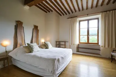 a bedroom with a bed and a desk and chairs at Le Presbytère de Bugarach in Bugarach