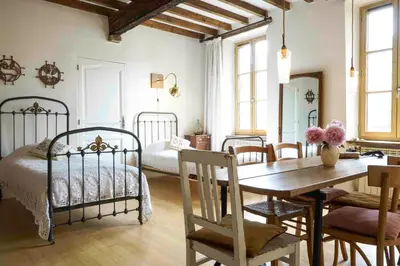 a bedroom with two beds and a table with a mirror at Le Presbytère de Bugarach in Bugarach
