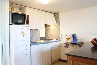 a kitchen with white cabinets and a white refrigerator at Maison 4 pièces 8 couchages PORT LA NOUVELLE PN000-001 in Port-la-Nouvelle
