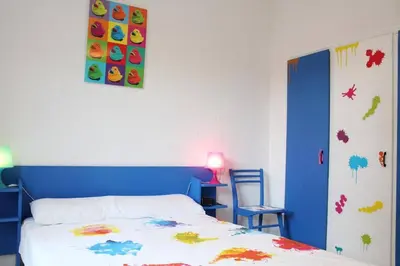 a bedroom with a bed with a blue head board at Maison 4 pièces 8 couchages PORT LA NOUVELLE PN000-001 in Port-la-Nouvelle
