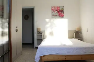 a bedroom with a bed with a white sheet on it at Maison 4 pièces 8 couchages PORT LA NOUVELLE PN000-001 in Port-la-Nouvelle