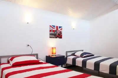 two beds in a room with white walls at Maison 4 pièces 8 couchages PORT LA NOUVELLE PN000-001 in Port-la-Nouvelle