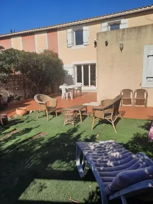 a yard with chairs and a table and chairs at Maison Gruissan village 90m2 avec jardin a 1km de la plage in Gruissan