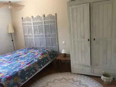 a bedroom with a bed and a cabinet and a table at Maison Gruissan village 90m2 avec jardin a 1km de la plage in Gruissan
