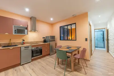a kitchen with a table and chairs in a room at La tavernne de Balaach Clim Wifi Cozy in Carcassonne