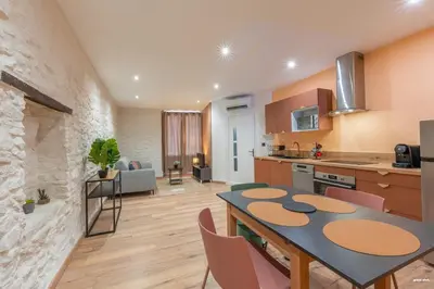 a kitchen and living room with a table and chairs at La tavernne de Balaach Clim Wifi Cozy in Carcassonne
