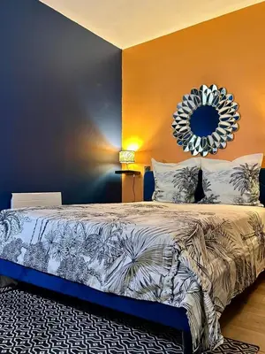 a bedroom with a large bed with a mirror on the wall at La tavernne de Balaach Clim Wifi Cozy in Carcassonne