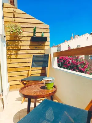 a patio with a table and chairs on a balcony at LE LOGIS, T2 au pied de la plage, Climatisation in Port-la-Nouvelle