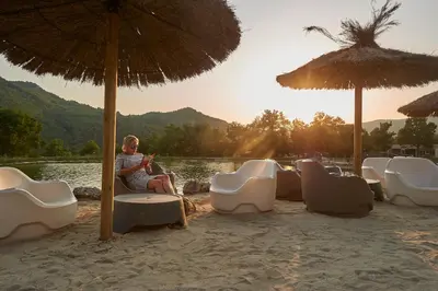 a person sitting on a beach under an umbrella at Domaine de l'Espinet in Quillan
