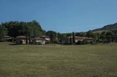 a large field with houses in the background at Domaine de l'Espinet in Quillan