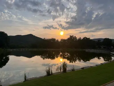 a view of a lake with the sunset in the background at Domaine de l'Espinet in Quillan