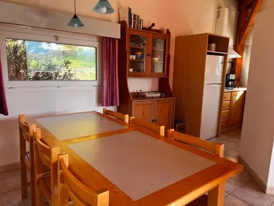 a kitchen with a dining room table and a refrigerator at Domaine de l'Espinet in Quillan