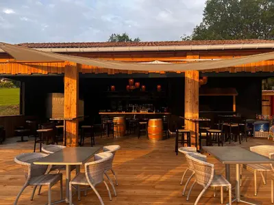 a patio with tables and chairs on a wooden deck at Domaine de l'Espinet in Quillan